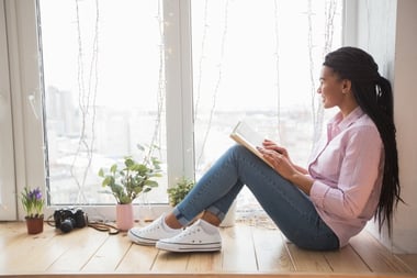 dreamy-female-student-with-book-sitting-on-window-sill_1262-3206.jpg