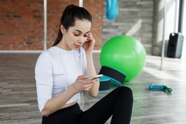 girl-works-with-her-smartphone-after-or-before-a-work-out-in-the-gym_8353-5534