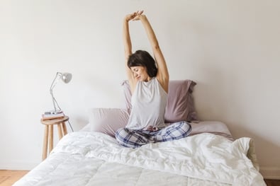 modern-woman-on-bed-stretching-her-arms_23-2147637561.jpg