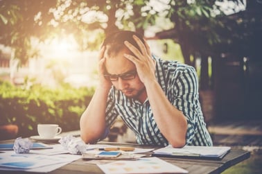 stressed-businessman-with-papers-and-charts-sitting-at-table-at-home-businessman-with-paperwork-and-deadline-concept_1150-1824.jpg