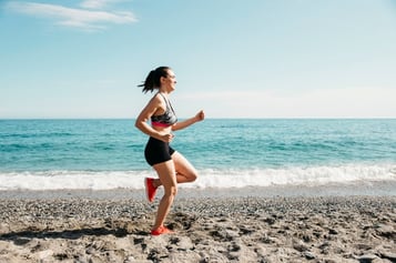 woman-running-at-the-beach_23-2147827018