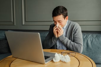 young-business-man-blows-his-nose-while-working-at-his-laptop-in-the-workplace_8353-5963